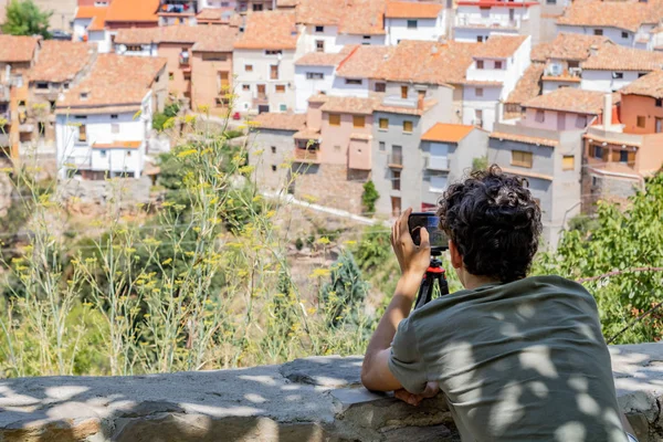 Bir kasabanın fotoğrafını çeken genç adam