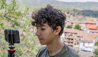 Bir kasabanın fotoğrafını çeken genç adam