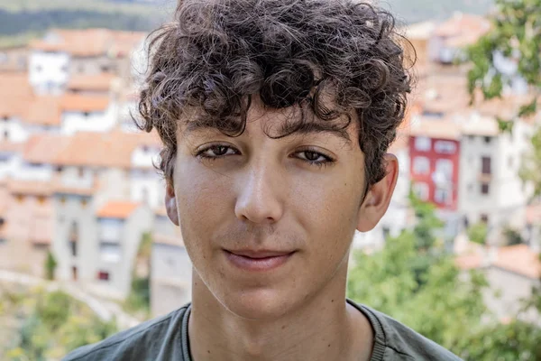 Arka planda eski bir dağ köyü ile genç adam Portresi