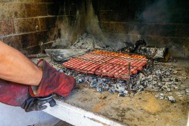 İzolasyon eldivenli bir adamın elleri ızgaraya çeşitli et türleriyle ızgara koyuyor. Lezzetli konsept