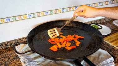 Valensiyalı bir paella 'nın yemek pişirme sürecine bakınca insan eliyle içindekileri çıkarıyor. Gastronomi kavramı
