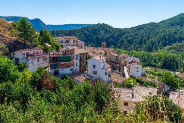 Bir dağın eteğinde, bir sürü yeşil bitki örtüsüyle çevrili güzel bir kırsal kasaba manzarası. Sağlıklı yaşam konsepti. Seçici odak