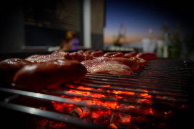 Sosisli, hamburgerli, domuzlu ve pastırmalı yarım yamalak barbekü manzarası. Seçici odak