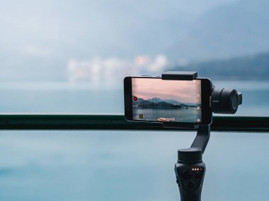 Cep telefonu ile bir gimbal stabilizatör dağ ve göl manzara bir timelapse alarak.