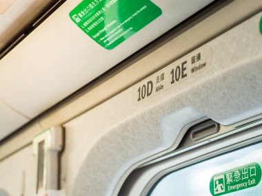 Taoyuan, Tayvan - 11 Mart 2019: Tayvan Yüksek Hızlı Tren (Thsr) ve Pencereden sarı güneş ışığı ile Acil Çıkış işareti closeup havai koltuk numaraları.