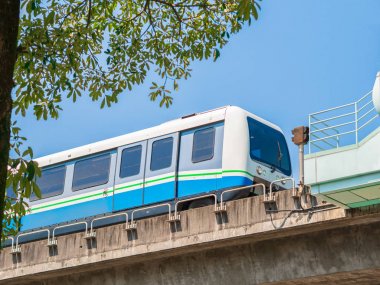 , Mavi açık gökyüzü ve ağaç yaprakları ile raylı Taipei Metro Tren.