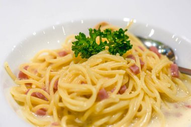 Beyaz plakalı jambonlu spagetti makarna carbonara'yı kapatın. En popüler İtalyan makarna yemekleri.