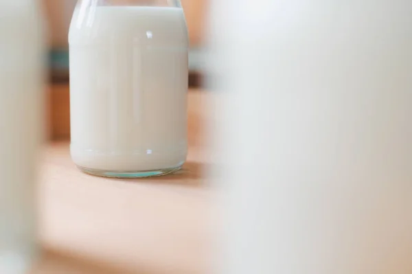 Fresh milk bottles on a wooden box near the window. A healthy drink concept. Copy space wallpaper.