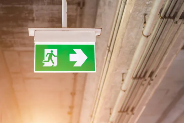 Emergency exit sign with right arrow at skytrain station. Safety first concept. Copy space wallpaper.