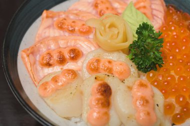 Yakın plan Aburi Hotate Somon Donburi Mentaiko soslu.