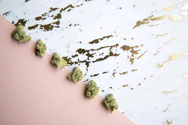 Μπουμπούκια Μαριχουάνα Κάθονται Διαγώνια Ροζ Και Χρυσό Μάρμαρο Κάνναβης Μινιμαλιστικό — Φωτογραφία Αρχείου