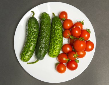 Bir yığın ıslak domates ve salatalık. Üst görünüm, tam çerçeve.