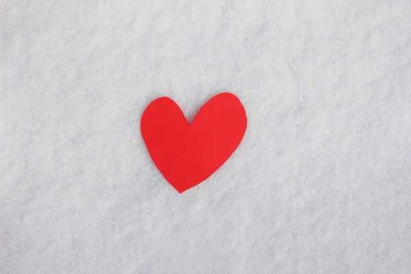 Single red heart on the snow, love concept