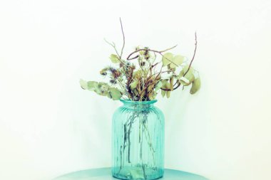 Kurutulmuş çiçeklerle minimal tarzda boş duvar mavi cam kavanoza dekorasyon için