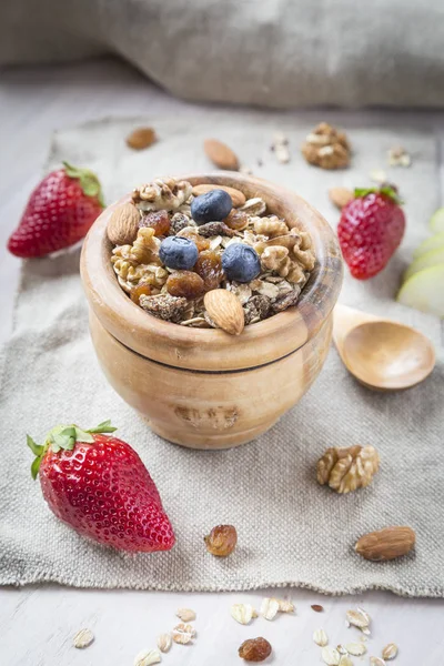 Healthy breakfast with muesli, almonds, blueberries, walnuts and strawberries on white background. Top view. — Stock Photo, Image