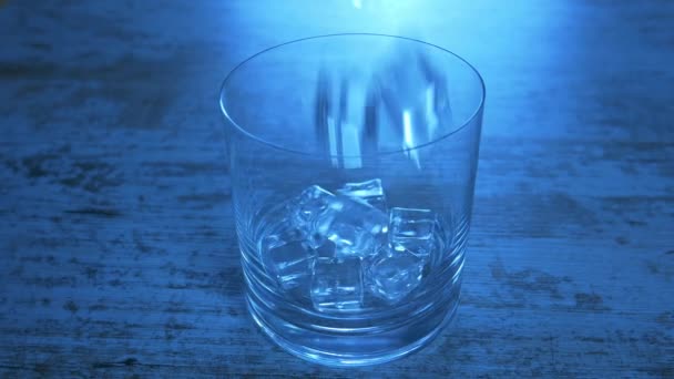 Soda rinfrescante al limone in un bicchiere. Primo piano di acqua di limone su sfondo blu. Cubi di ghiaccio e limone che cadono . — Video Stock