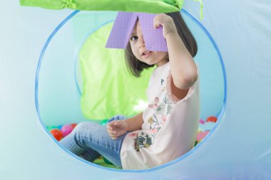 Beyzbol sahasında yalan söyleyen gülümseyen küçük kız. Yaklaş, portre.