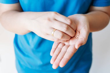 Genç bir kadın ellerini farklı pozisyonlara sokuyor..