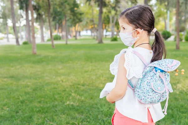 带着面具和背包的女孩从学校回来了Coronavirus 案文的篇幅 — 图库照片