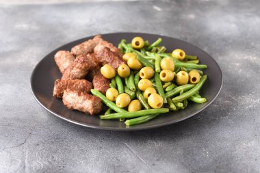 Fasulye kabukları, zeytin ve kızarmış Türk pirzolası..