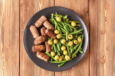 Fasulye kabukları, zeytin ve kızarmış Türk pirzolası..