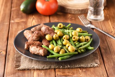 Fasulye kabukları, zeytin ve kızarmış Türk pirzolası..