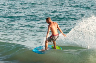 Genç sportif adam deniz dalgaları üzerinde sörf