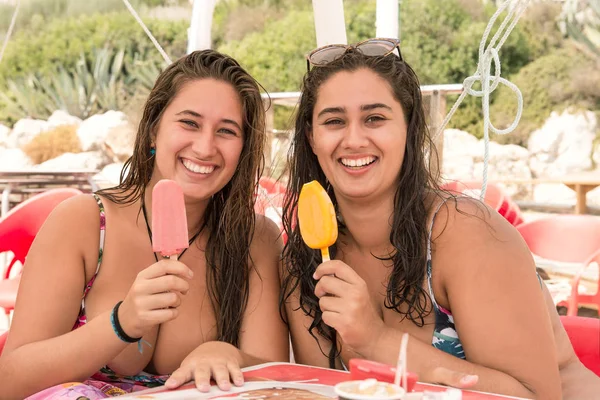 ビーチで楽しくアイスクリームを食べる若い女性 — ストック写真