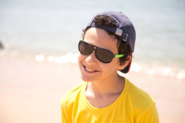 Kumlu sahilde genç çocuğun yakın görüş portresi