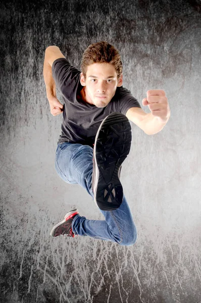 十几岁的男孩跳上灰色的背景 — 图库照片