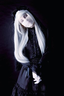 Karanlık bir arka planda izole edilmiş ürkütücü insan bebeği.