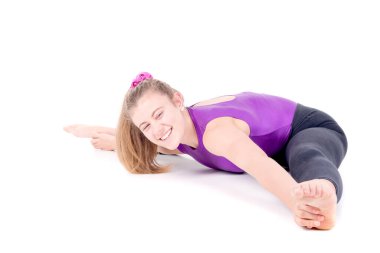 Genç jimnastikçi beyazlar içinde yalnız poz veriyor.