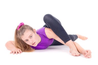 Genç jimnastikçi beyazlar içinde yalnız poz veriyor.