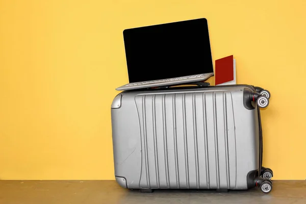 ラップトップ および銀色の旅行スーツケース インターネットと旅行の概念 黄色の背景にパスポート — ストック写真