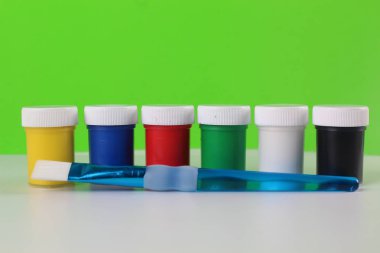 Yeşil ve beyaz arka plan üzerinde izole çocuklar için guaj boyaları ayarlayın