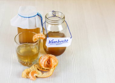 fermente içecek, bir bardak ve mandalina içmeye hazır bir cam kavanozda jun çay sağlıklı doğal probiyotik