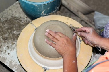 bir çömlekçi elleri, daire üzerinde bir kase oluşturma, son adımda 2 el ile Çömlekçilik parlatma işlemi. Fırına girmeden önce.