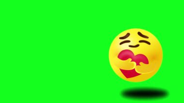 Dikkat emojisi - büyük parlak gözleri olan sarı yüz iki eliyle kırmızı bir kalbe sarılıyor, Chroma anahtarı için yeşil arka plan