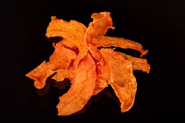 Olgun ve tatlı kabak siyah bir zemin üzerine parlak, portakal, gevrek snack