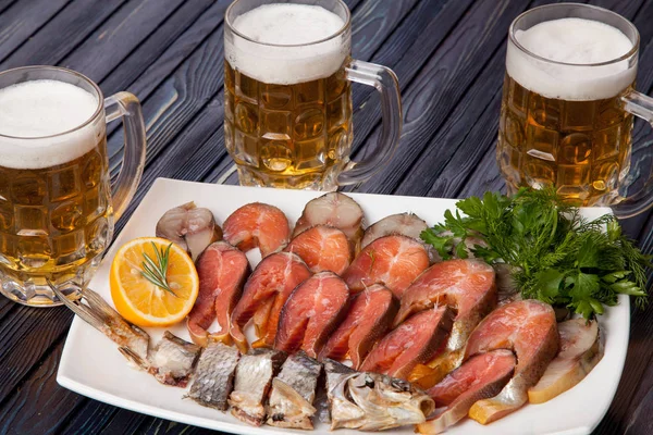 appetizer for beer from dried fish, cheese sticks, smoked onion cheese and loafs with beer on the table for use in design