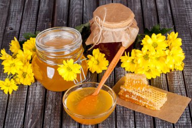 Bal ürünleri, tatlım, peteğin, metin ve ürünler için alanı ile ahşap bir masaya Perge ve yaz çiçek güzel kompozisyon