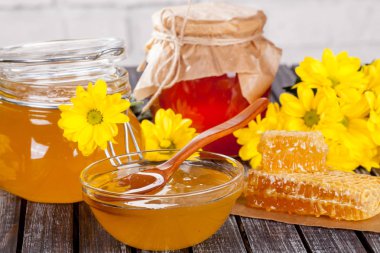 Bal ürünleri, tatlım, peteğin, metin ve ürünler için alanı ile ahşap bir masaya Perge ve yaz çiçek güzel kompozisyon