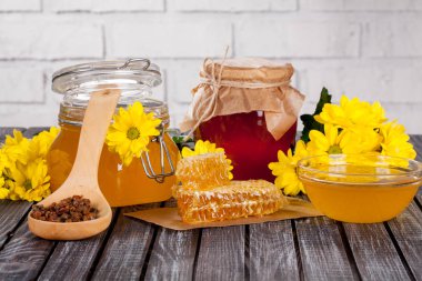 Bal ürünleri, tatlım, peteğin, metin ve ürünler için alanı ile ahşap bir masaya Perge ve yaz çiçek güzel kompozisyon