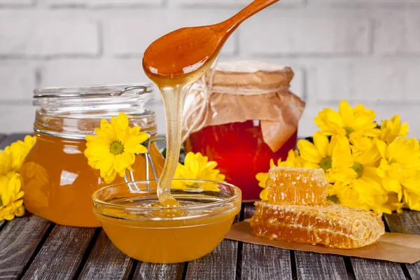 Bal ürünleri, tatlım, peteğin, metin ve ürünler için alanı ile ahşap bir masaya Perge ve yaz çiçek güzel kompozisyon