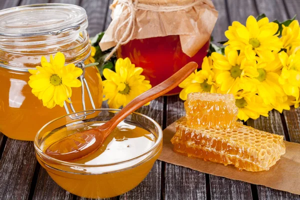 Bal ürünleri, tatlım, peteğin, metin ve ürünler için alanı ile ahşap bir masaya Perge ve yaz çiçek güzel kompozisyon