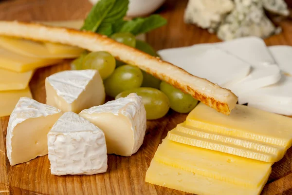 delicious cheese plate or cheese platter from several types of cheese with honey and fruit for creative work in cooking