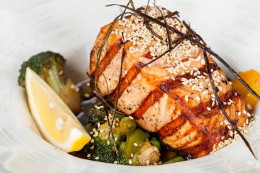 iştah açıcı kızarmış balık, güzel ortaya konulan Yeşiller ve pişirme tasarım çözümleri için bir yemek üzerinde sebze ile