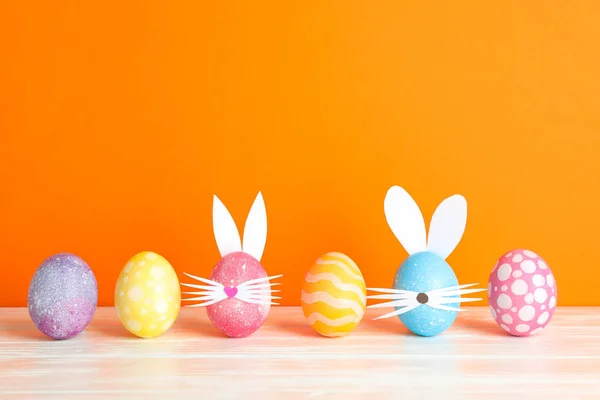 Paskalya Yumurtaları Sevimli Tavşan Kulakları Renk Arka Plan Karşı Masada — Stok fotoğraf