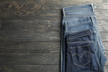 Ahşap arka plan, metin için yer üzerinde katlanmış farklı kot pantolon