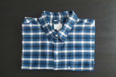 Kareli gömlek siyah masada, üstten görünüm katlanmış